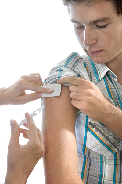 A young man getting an injection into his arm.