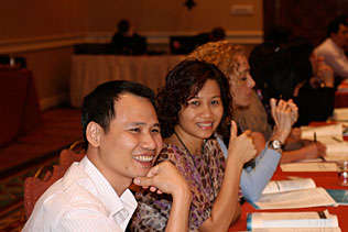 Thai N. Hoang, Vietnam and Minh Huong, Vietnam, smiling while sitting and listening during the plenary session.
