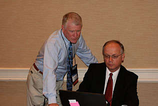 Mike Walsh, The Walsh Group and Alain Verstraete, Belgium looking at a laptop screen.