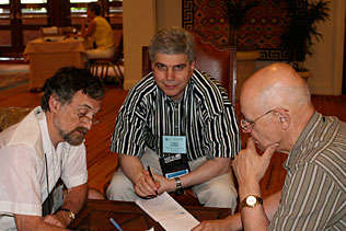 Jeff Samet, Boston University; Evgeny Krupitsky, Russia; and Edwin Zvartau, Russia sitting around a table discussing notes.