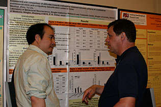 Wenhua Zhou, China listening to Dave Shurtleff, NIDA in front of Dr. Zhous poster presentation.