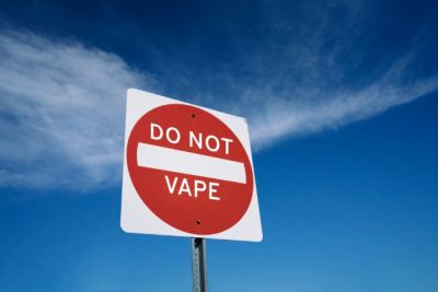 Do Not Vape on red and white sign against blue sky.