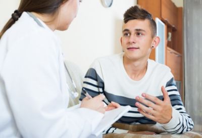 A health care provider talks with a teen.