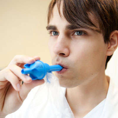 The picture shows a person breathing into a hand-held Breathalyzer-type breath-collection device. The device contains a small filter pad, which captures exhaled compounds (such as marijuana metabolites). The pad is used in subsequent chemical analyses to determine concentrations of the captured breath compounds.