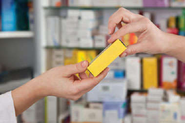 This is a photo of a pharmacist handing medication to a patient.
