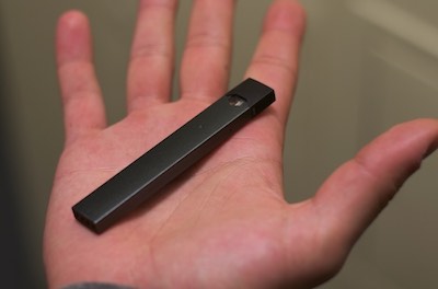 iIage of a JUUL e-cigarette device in a hand
