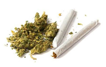 Two joints and a stash of marijuana on white background