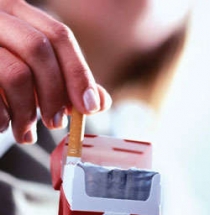 Photo of hand removing cigarette from packet
