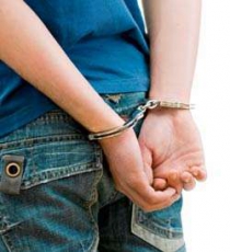 Boy's back showing wrists in handcuffs